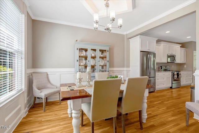 2062 Montgomery Dr, Franklinton, NC 27525 - dining space featuring a chandelier, a decorative wall, light wood-style floors, wainscoting, and crown molding