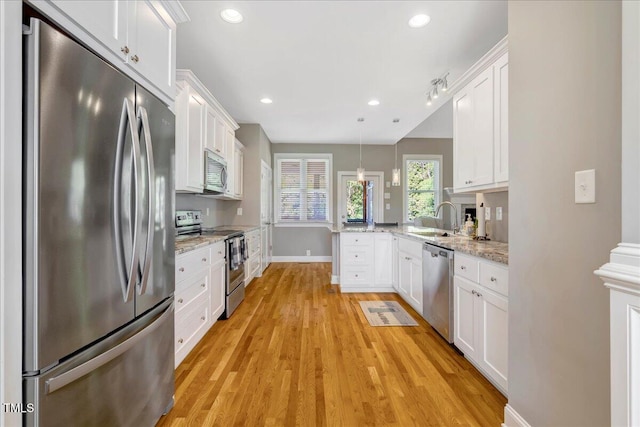 2062 Montgomery Dr, Franklinton, NC 27525 - kitchen featuring stainless steel appliances, a sink, a peninsula, white cabinetry, and baseboards