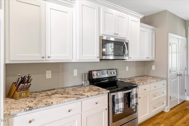 2062 Montgomery Dr, Franklinton, NC 27525 - kitchen featuring stainless steel appliances, white cabinets, light wood finished floors, and light stone counters
