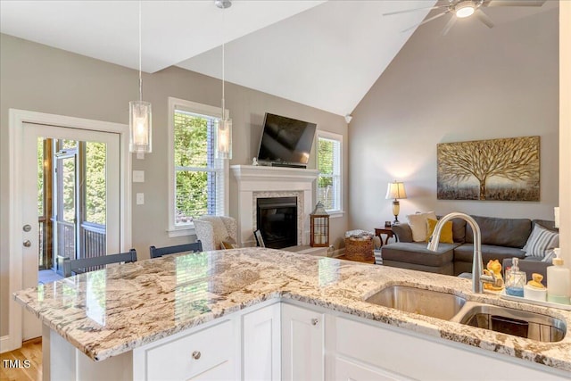 2062 Montgomery Dr, Franklinton, NC 27525 - kitchen featuring a sink, open floor plan, light stone counters, plenty of natural light, and high vaulted ceiling