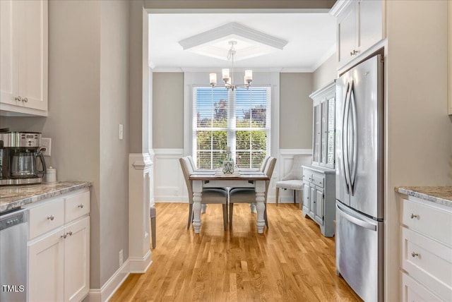 2062 Montgomery Dr, Franklinton, NC 27525 - kitchen with appliances with stainless steel finishes, ornamental molding, a chandelier, light wood-style flooring, and white cabinetry