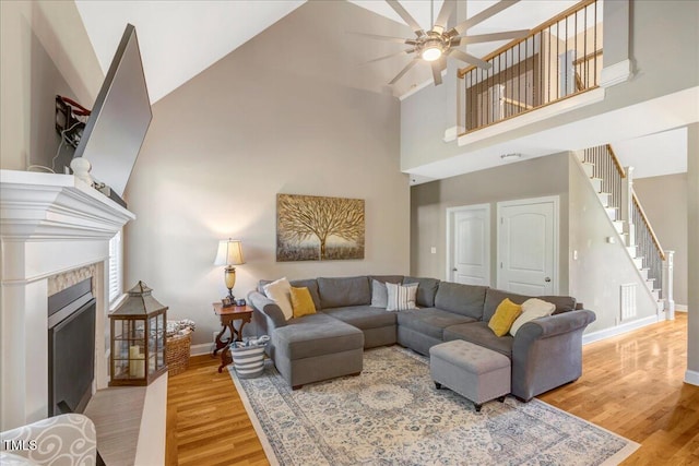 2062 Montgomery Dr, Franklinton, NC 27525 - living room with a towering ceiling, stairs, wood finished floors, a ceiling fan, and baseboards