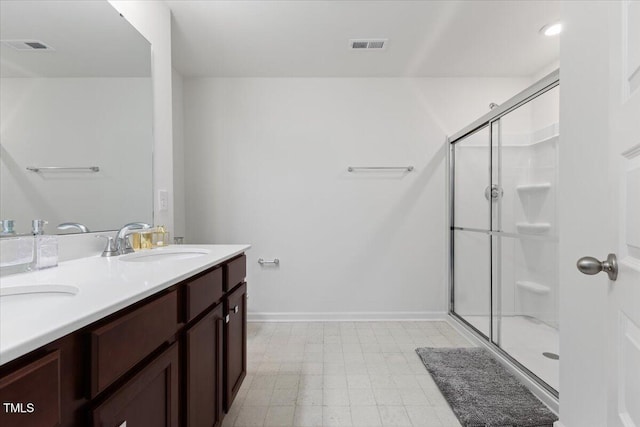 bathroom featuring visible vents, a stall shower, a sink, baseboards, and tile patterned floors