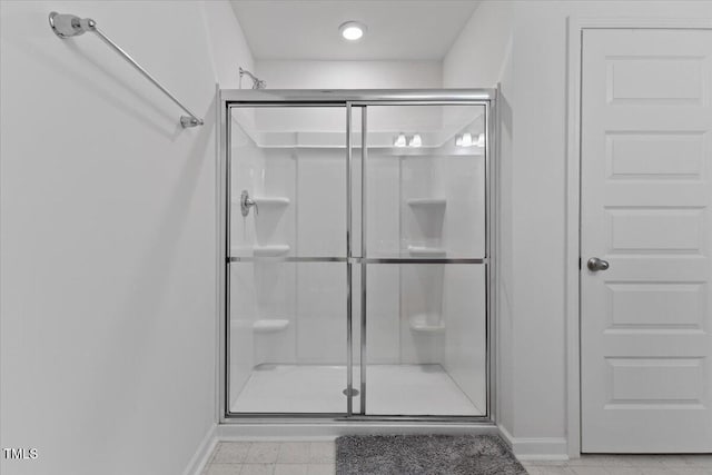 full bathroom with baseboards and a shower stall