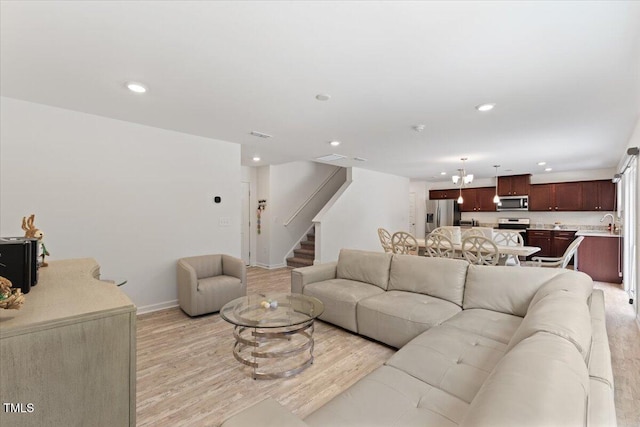 living room featuring recessed lighting, stairs, baseboards, and light wood-type flooring