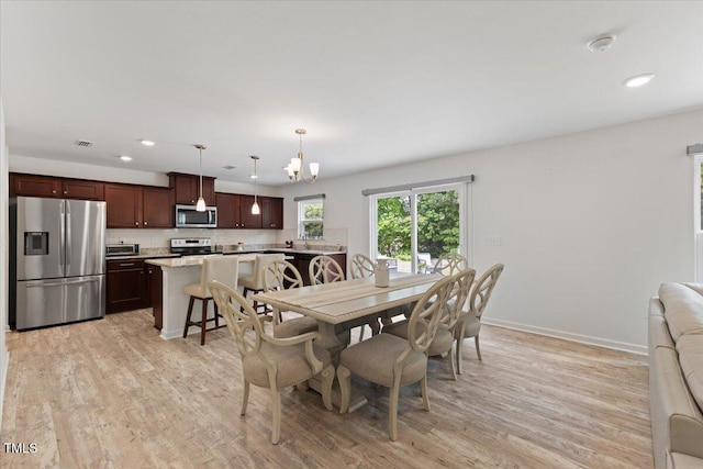 dining room featuring recessed lighting, light wood finished floors, baseboards, and a chandelier