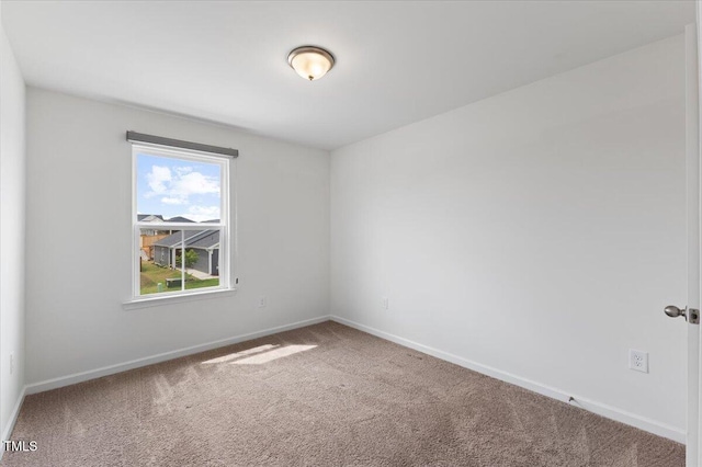 carpeted empty room with baseboards