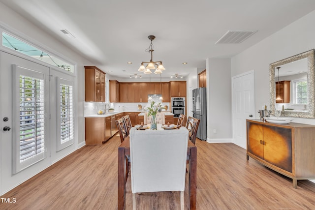 dining room with visible vents, baseboards, a chandelier, and light wood-type flooring