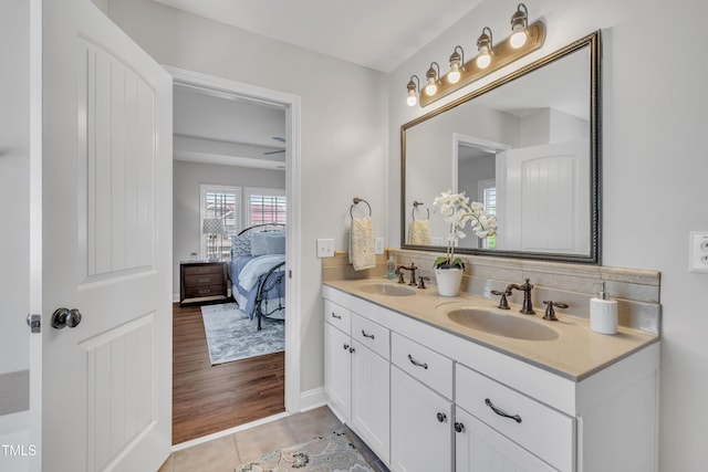 full bathroom with a sink, tile patterned floors, tasteful backsplash, and double vanity