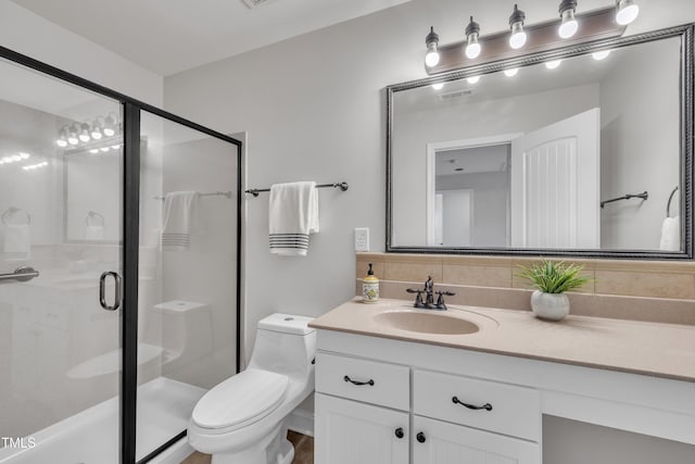 bathroom featuring vanity, tasteful backsplash, a shower stall, and toilet