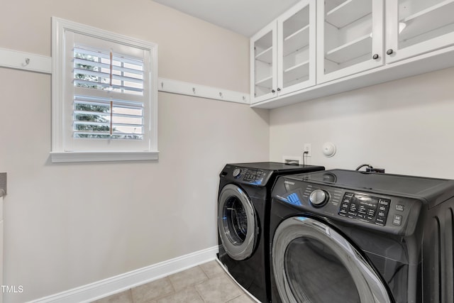 laundry room featuring separate washer and dryer, tile patterned flooring, cabinet space, and baseboards