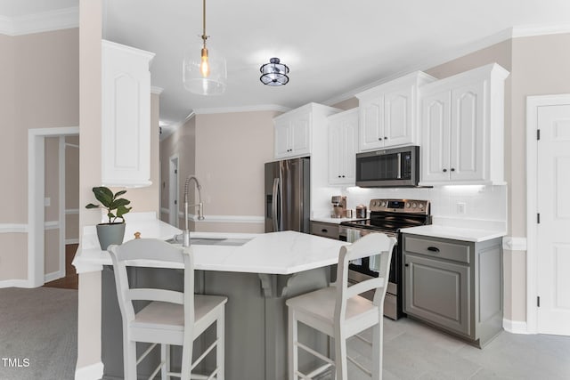 205 Carlyle Cir, Goldsboro, NC 27530 - kitchen featuring stainless steel appliances, gray cabinetry, a breakfast bar, decorative backsplash, and a sink