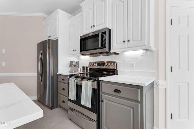 205 Carlyle Cir, Goldsboro, NC 27530 - kitchen featuring stainless steel appliances, decorative backsplash, white cabinetry, crown molding, and light stone counters
