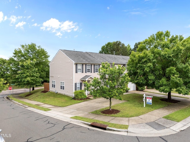 view of front facade with driveway, a shingled roof, a front lawn, and a garage
