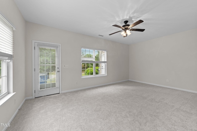 carpeted empty room featuring visible vents, baseboards, and a ceiling fan