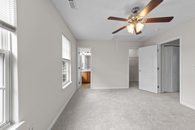 unfurnished bedroom with light colored carpet, attic access, visible vents, and multiple windows