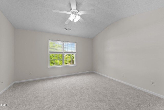 carpeted empty room with a textured ceiling, visible vents, baseboards, and lofted ceiling