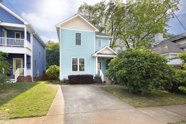 view of front of house featuring a balcony and a front yard