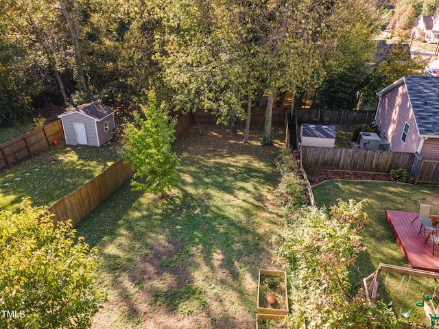 view of yard with a fenced backyard, a storage unit, and an outdoor structure