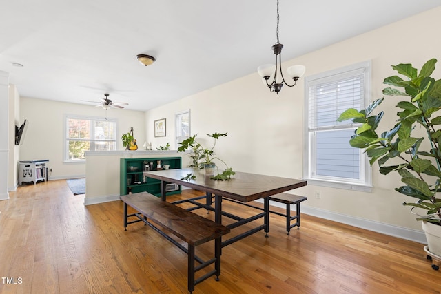 dining area featuring baseboards, ceiling fan, and light wood-style floors