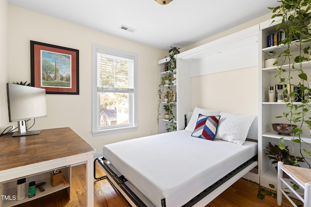 bedroom with visible vents and wood finished floors