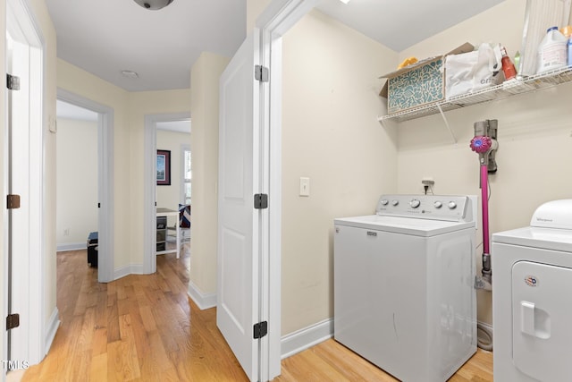 laundry room with separate washer and dryer, baseboards, laundry area, and light wood finished floors