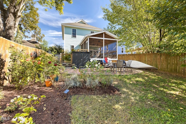 back of property with a sunroom, a fenced backyard, a patio area, and a lawn