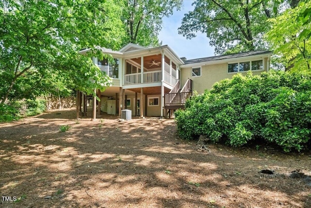 rear view of house featuring ceiling fan, a sunroom, central AC unit, stairway, and a carport