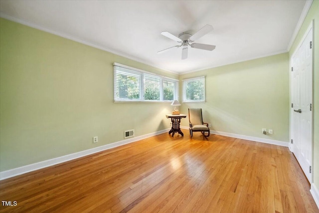 unfurnished room featuring crown molding, ceiling fan, light wood-style floors, and visible vents