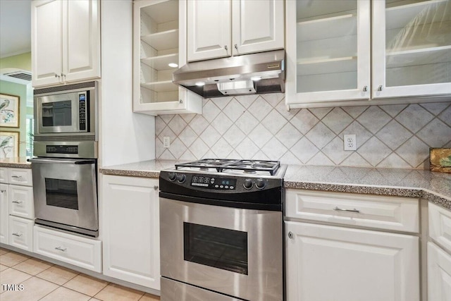 kitchen featuring under cabinet range hood, backsplash, white cabinets, and appliances with stainless steel finishes