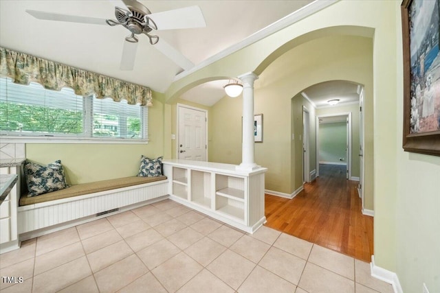 unfurnished room featuring visible vents, arched walkways, ceiling fan, and light tile patterned floors