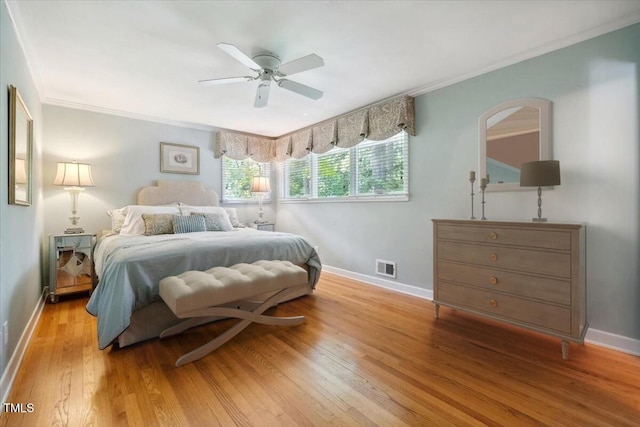 bedroom featuring visible vents, arched walkways, light wood-type flooring, baseboards, and ornamental molding