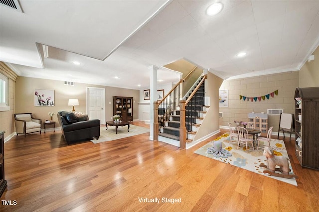 living room with baseboards, ornamental molding, wood finished floors, and visible vents