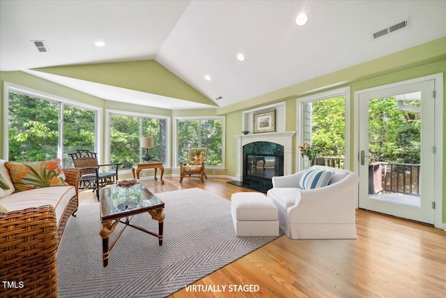 living area featuring a high end fireplace, recessed lighting, light wood-style flooring, and visible vents
