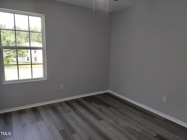 spare room with dark wood-style flooring, baseboards, and ceiling fan