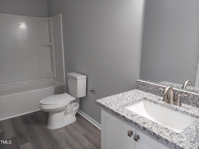 bathroom featuring vanity, shower / bathtub combination, toilet, baseboards, and wood finished floors