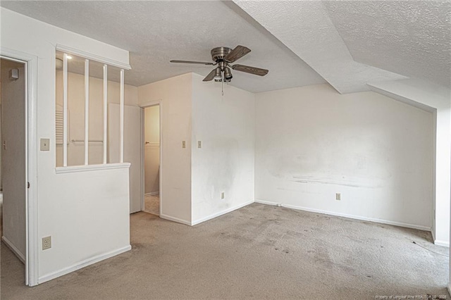 interior space with carpet floors, ceiling fan, baseboards, and a textured ceiling