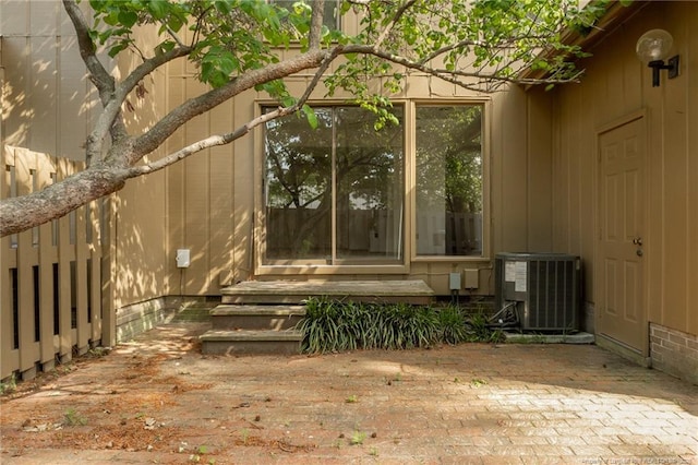 view of exterior entry featuring central air condition unit