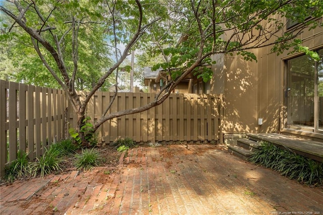 view of gate with a fenced backyard and a patio area