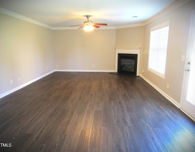 unfurnished living room featuring crown molding, dark wood-style flooring, ceiling fan, a glass covered fireplace, and baseboards