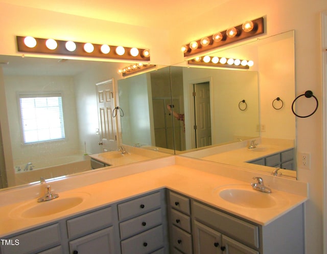 bathroom featuring a sink, a bath, and double vanity