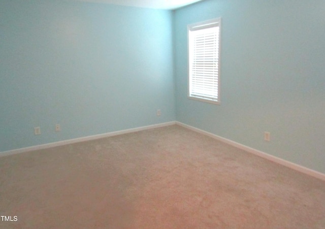 unfurnished room with baseboards and light colored carpet