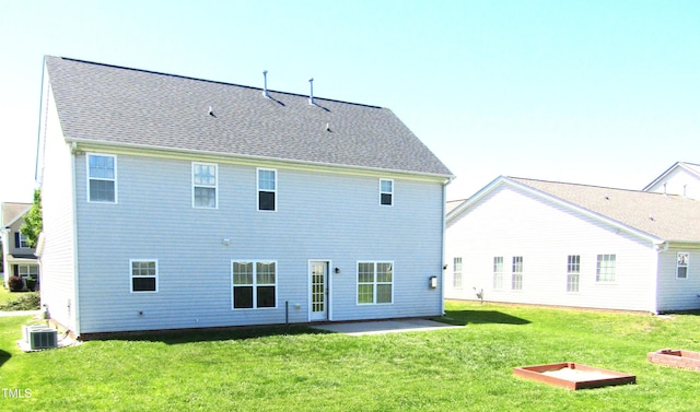 back of house with a lawn, central AC unit, a patio area, and roof with shingles