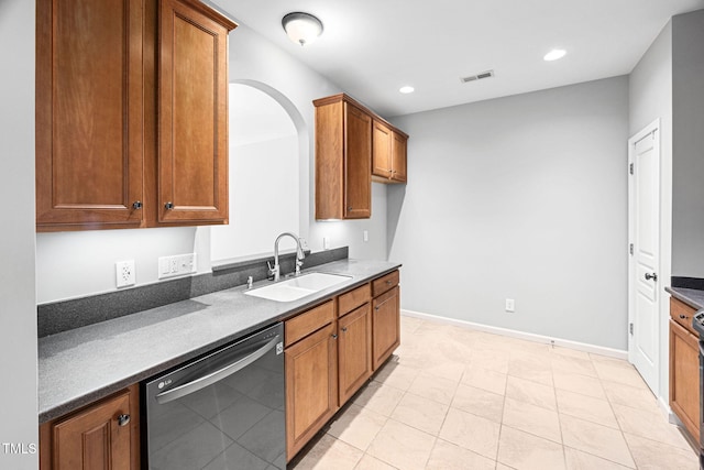 kitchen featuring brown cabinetry, visible vents, dark countertops, dishwasher, and a sink