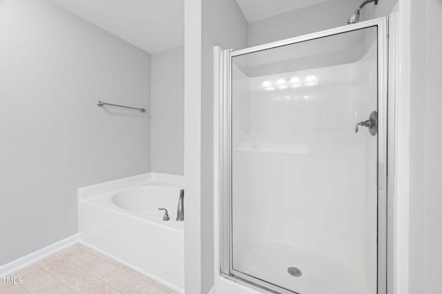 bathroom with baseboards, a stall shower, tile patterned floors, and a bath