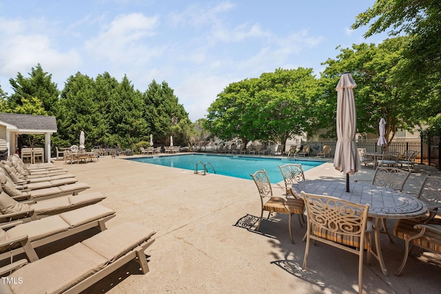 community pool with a patio and fence