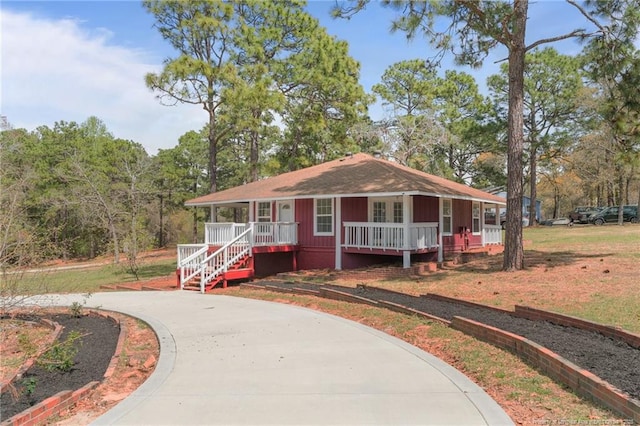 view of front of house featuring curved driveway and a porch