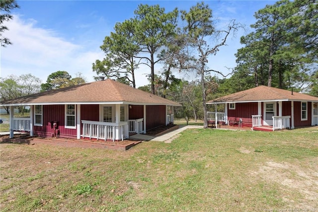 back of property featuring a porch and a yard