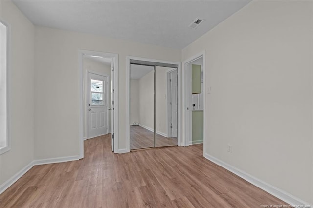 unfurnished bedroom with baseboards, visible vents, and light wood-style flooring