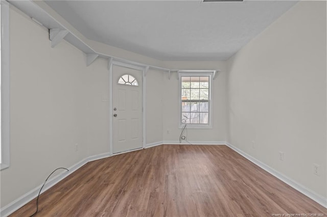 foyer with baseboards and wood finished floors